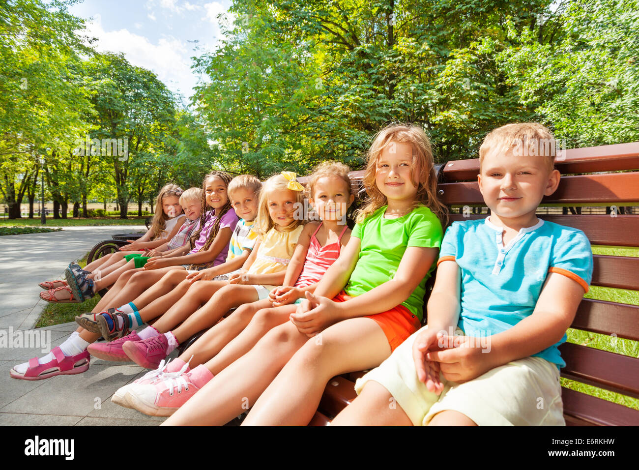 Grand groupe d'enfants assis sur le banc Banque D'Images