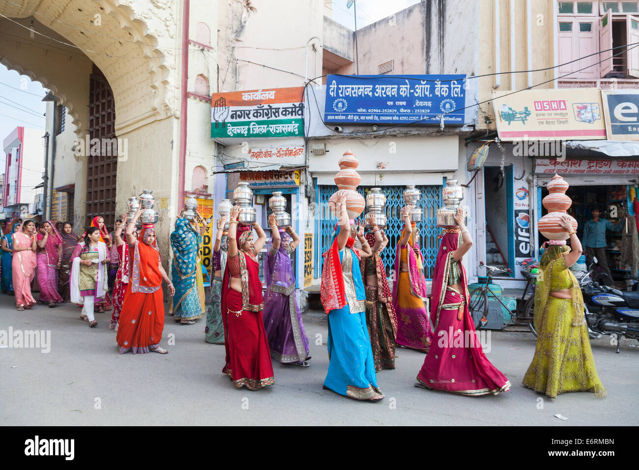 Procession traditionnelle de mariage à Deogarh, Rajasthan, Inde: Les femmes locales vêtues de saris colorés portent des pots sur leur tête Banque D'Images