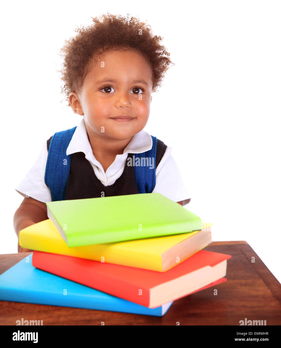 Portrait of cute little boy wearing school uniform avec de nombreux livres colorés isolé sur fond blanc, faire ses devoirs Banque D'Images