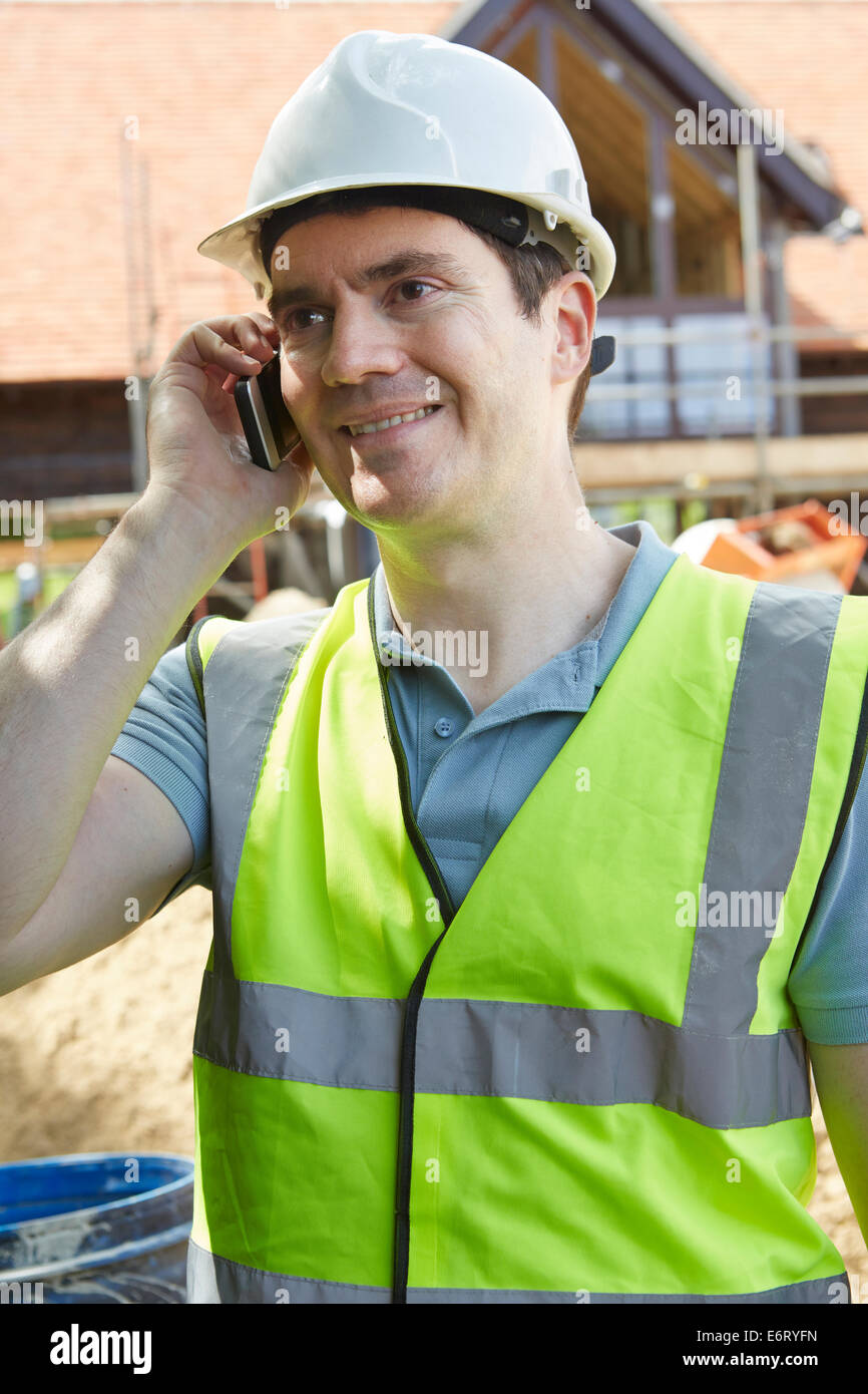 Travailleur de la construction sur la construction de site à l'aide de téléphone mobile Banque D'Images