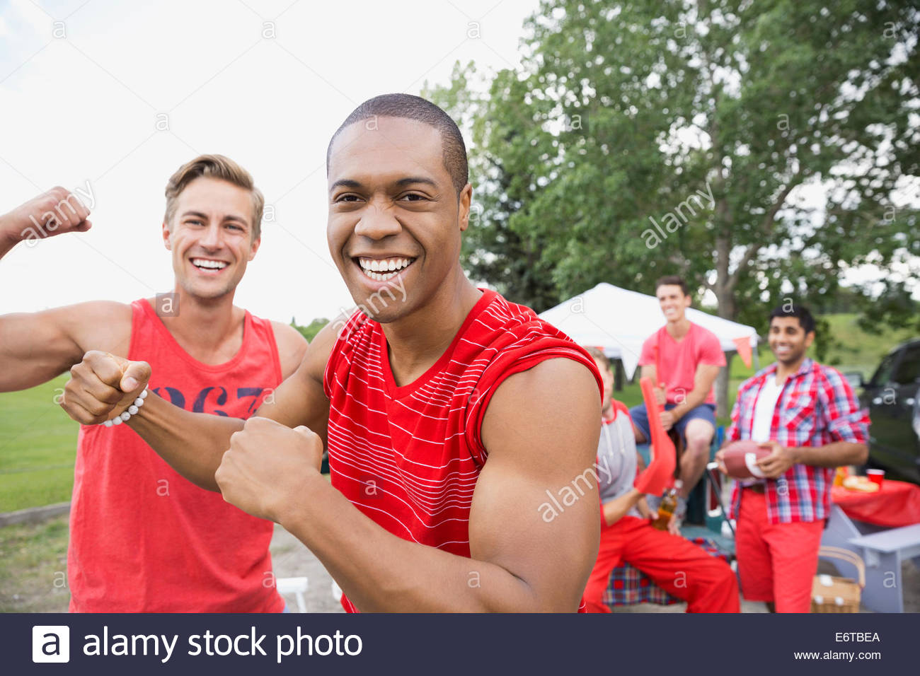 Les hommes flexing muscles au barbecue dans la zone de la porte arrière