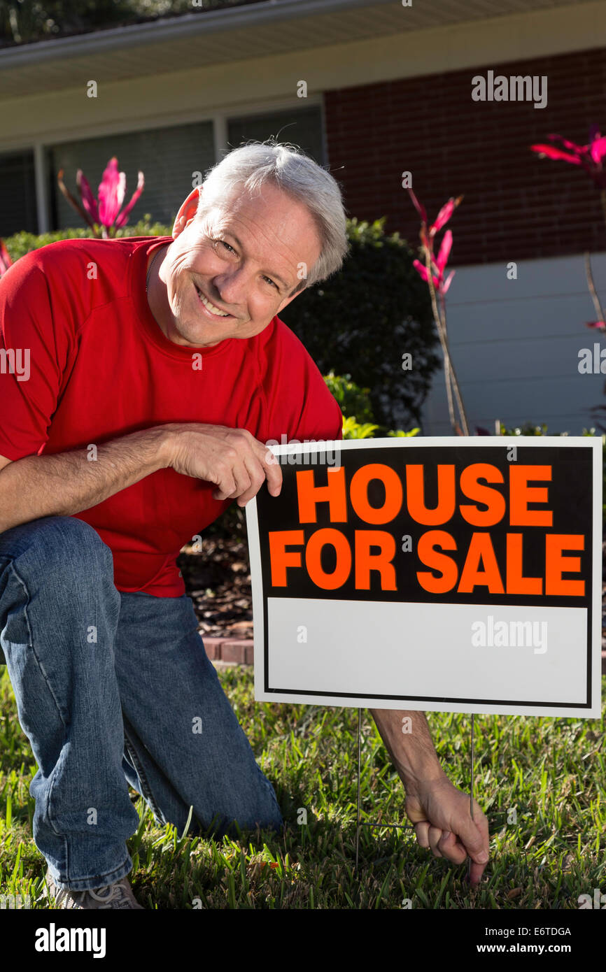 Propriétaire de maison mature plaçant sa maison de banlieue à la vente. USA Banque D'Images