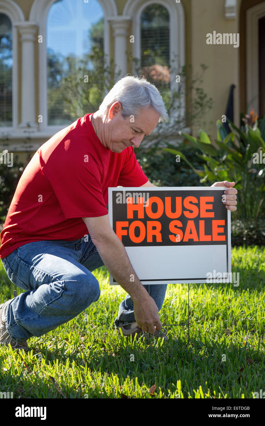 Propriétaire de maison mature plaçant sa maison de banlieue à la vente. USA Banque D'Images