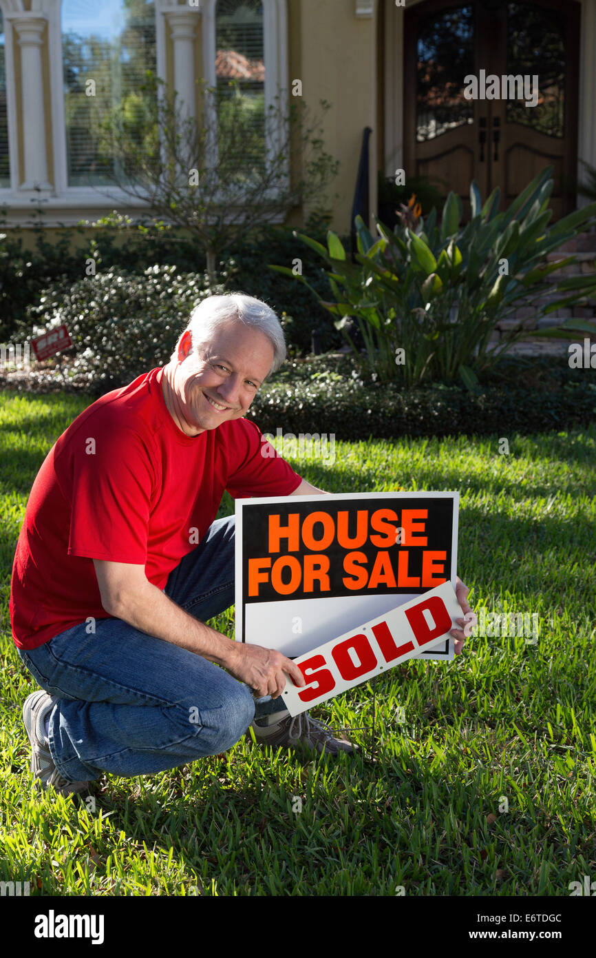 Propriétaire de maison mature plaçant sa maison de banlieue à la vente. USA Banque D'Images