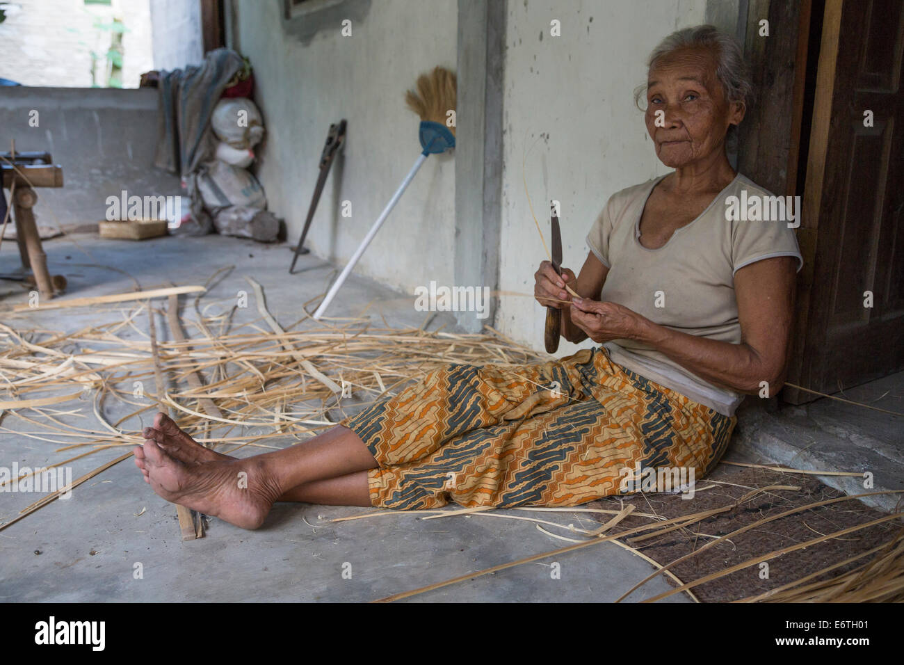 Yogyakarta, Java, Indonésie. Vieille Femme La préparation de palmier pour Basket-Making. Banque D'Images