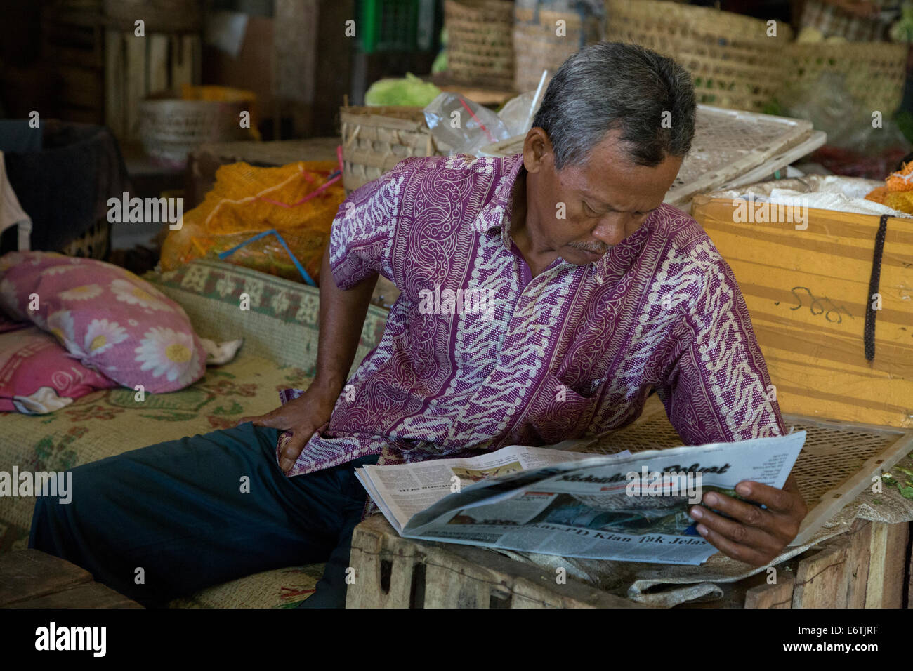 Yogyakarta, Java, Indonésie. Man reading Newspaper, Beringharjo marché. Banque D'Images