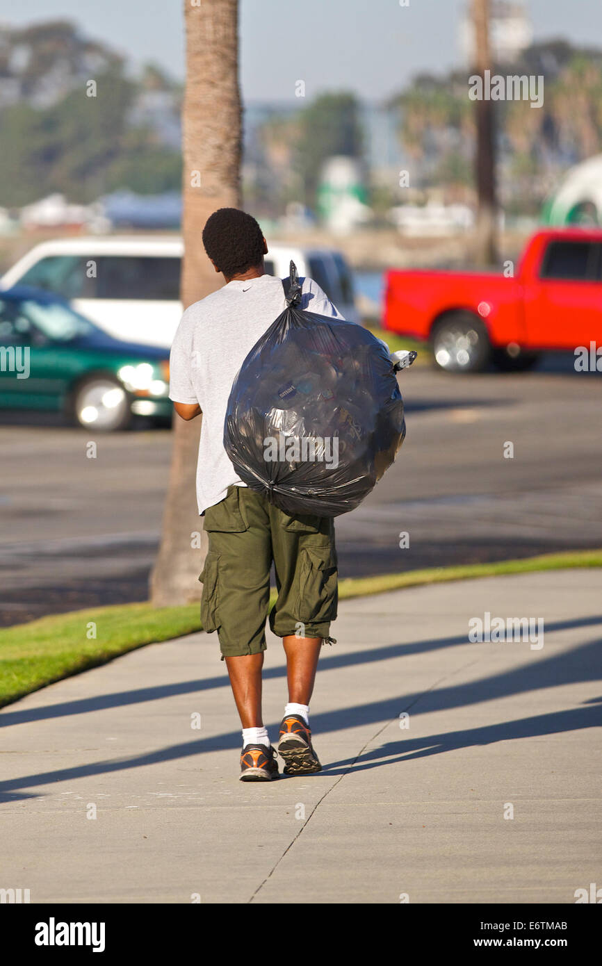 L'homme recueille des boîtes vides de poubelles à Long Beach, en Californie. Banque D'Images