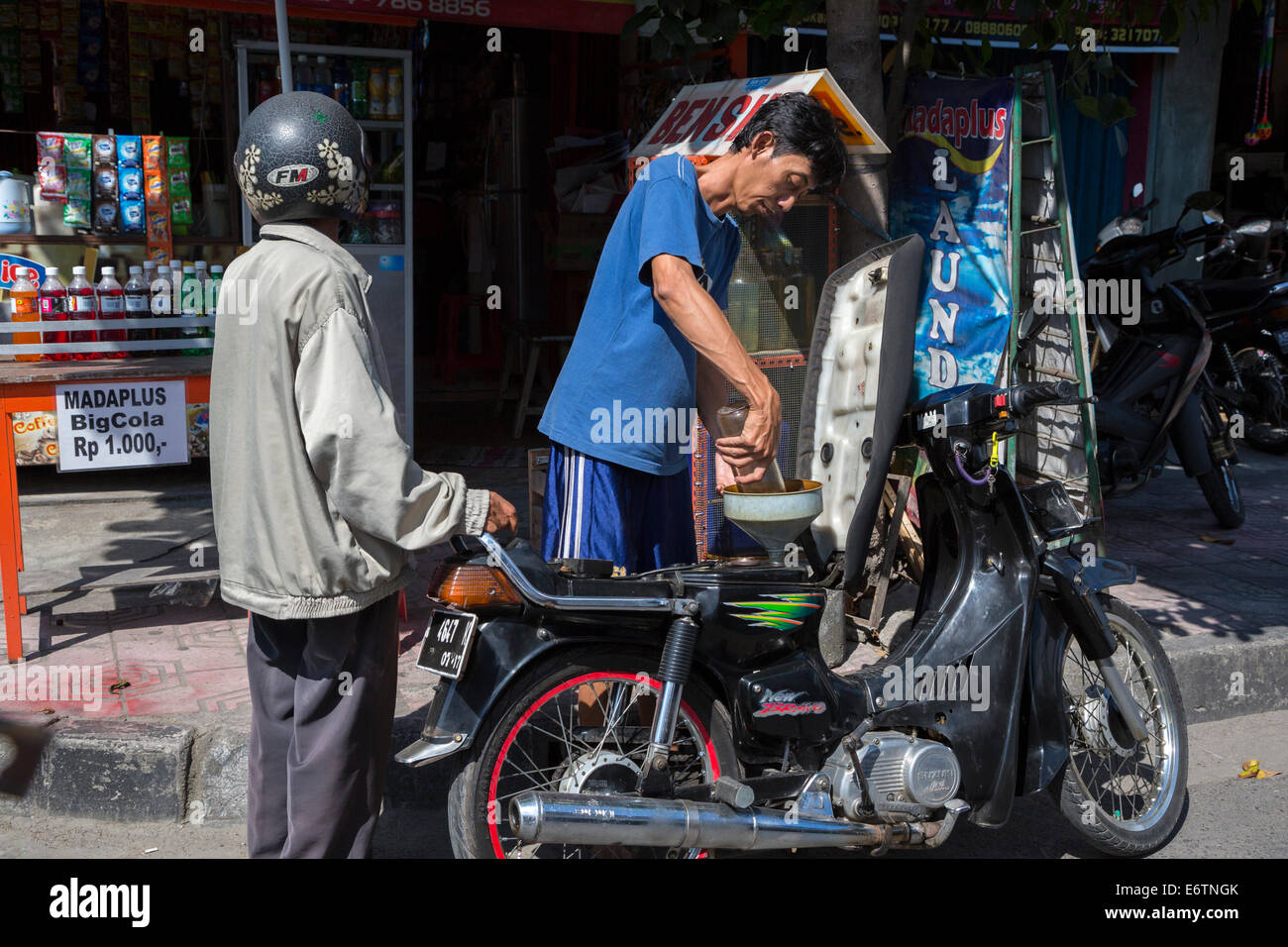 Yogyakarta, Java, Indonésie. L'achat de l'essence au litre. Banque D'Images