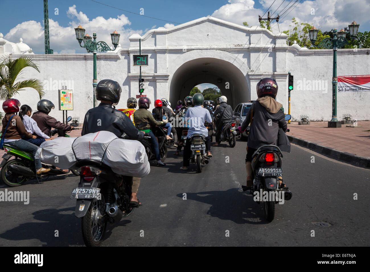 Yogyakarta, Java, Indonésie. Moto le trafic passant par la sortie sud du palais du Sultan, le Kraton. Banque D'Images