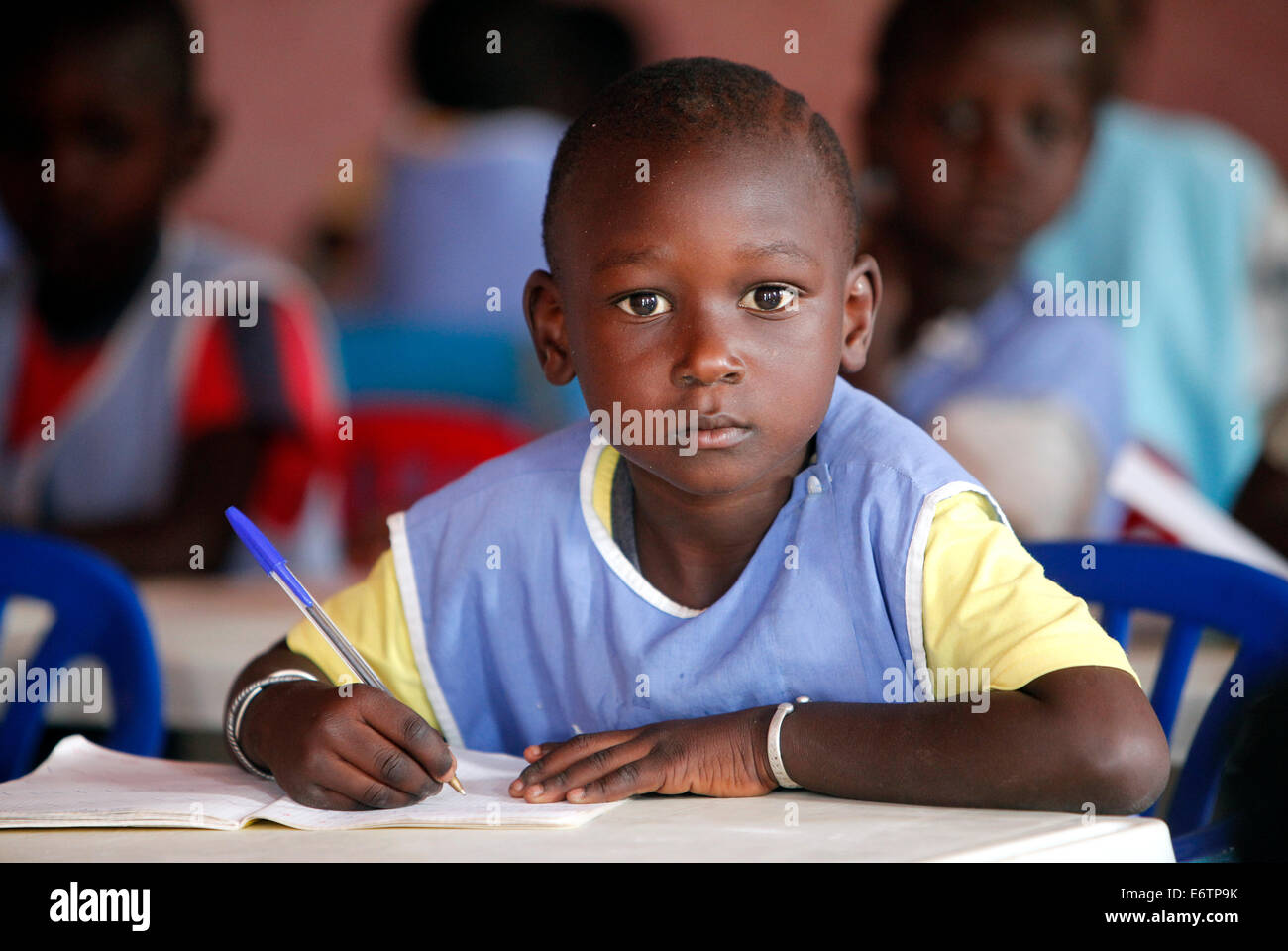 Garçon avec stylo écrit dans un jardin d'école à Fadiouth, Sénégal Banque D'Images