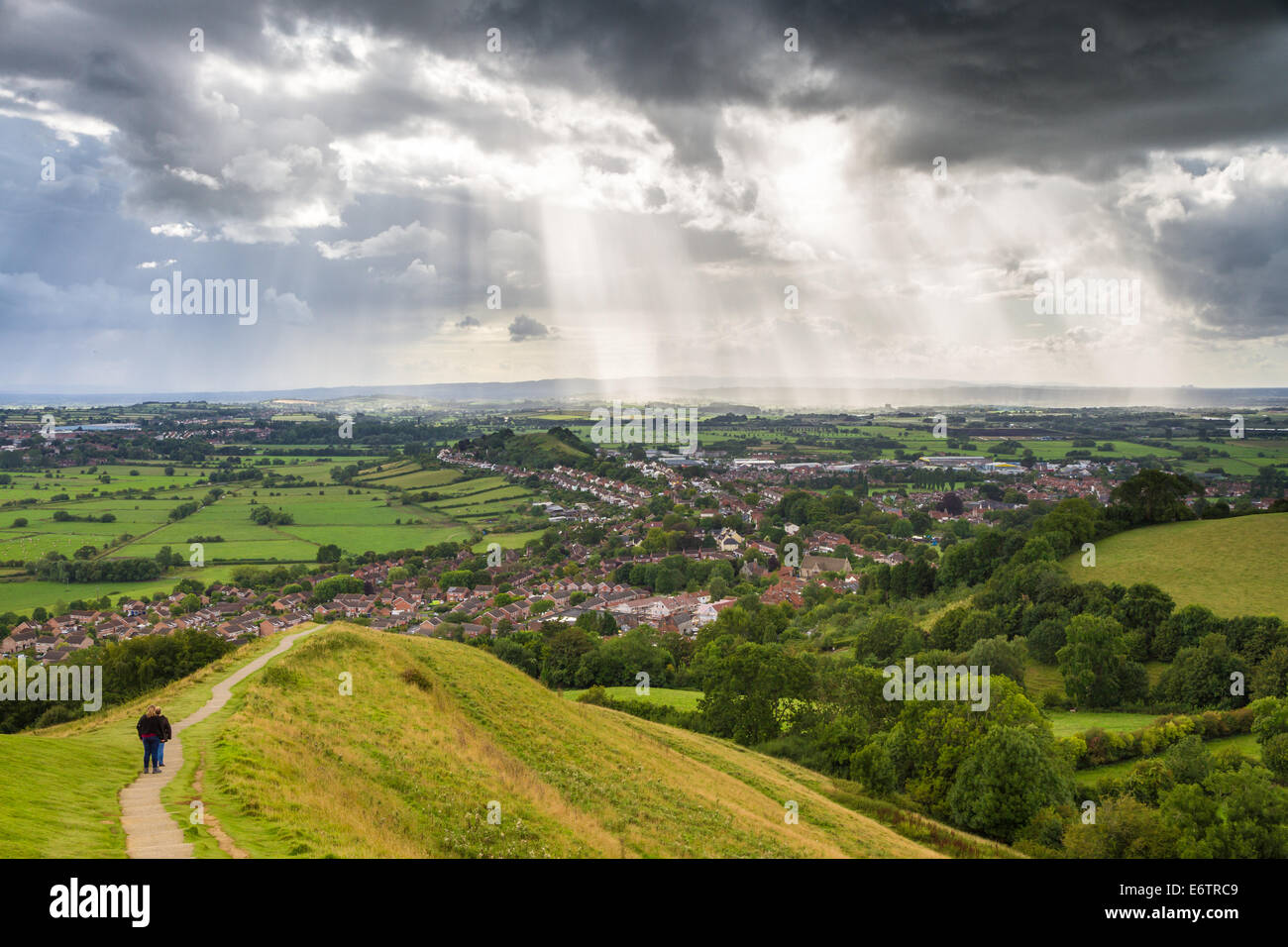 Vue depuis le haut de Glastonbury Tor avec rayons de lumière du soleil à travers les nuages orageux. Banque D'Images
