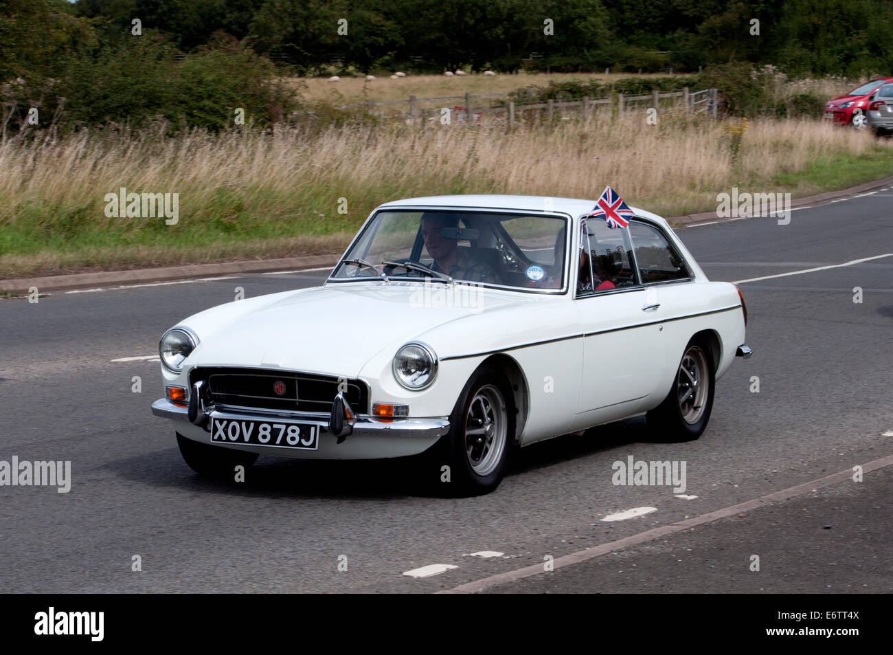 MGB GT voiture sur la Fosse Way road, Warwickshire, UK Banque D'Images