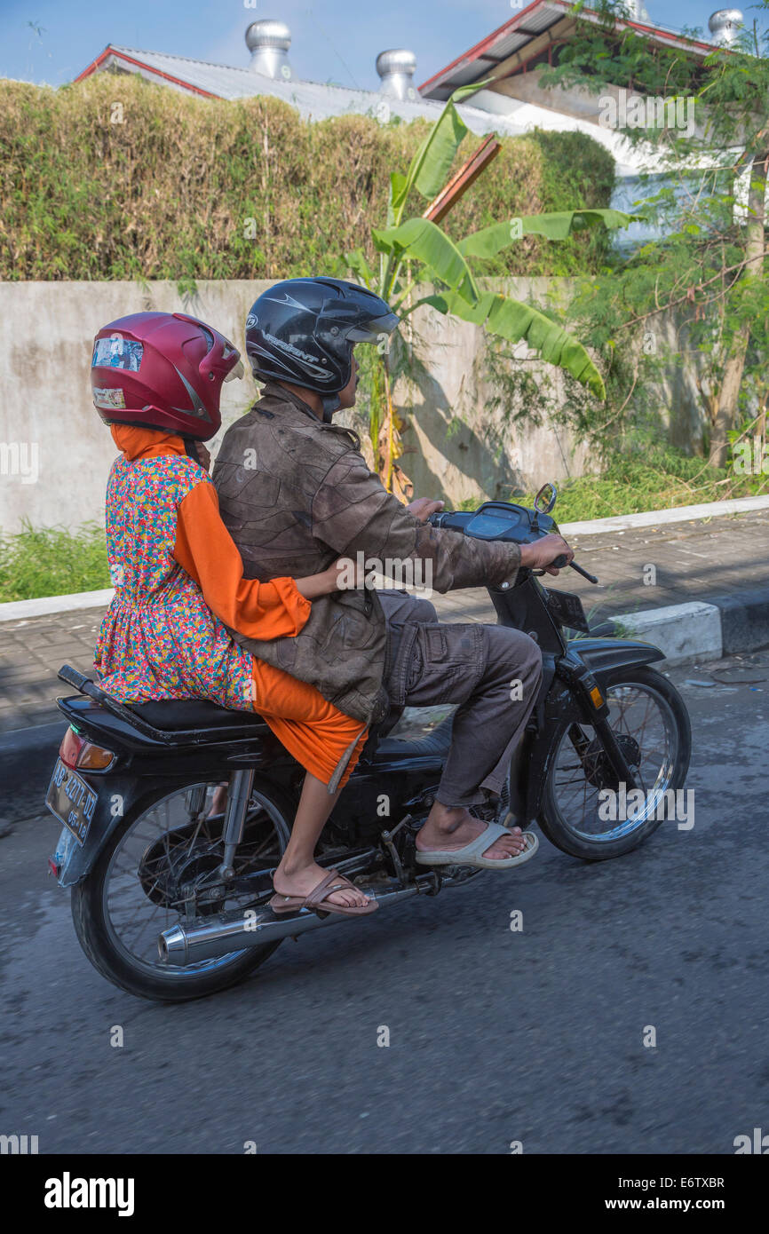 Yogyakarta, Indonésie. En moto, le trafic de la rue. Deux coureurs avec des casques. Banque D'Images