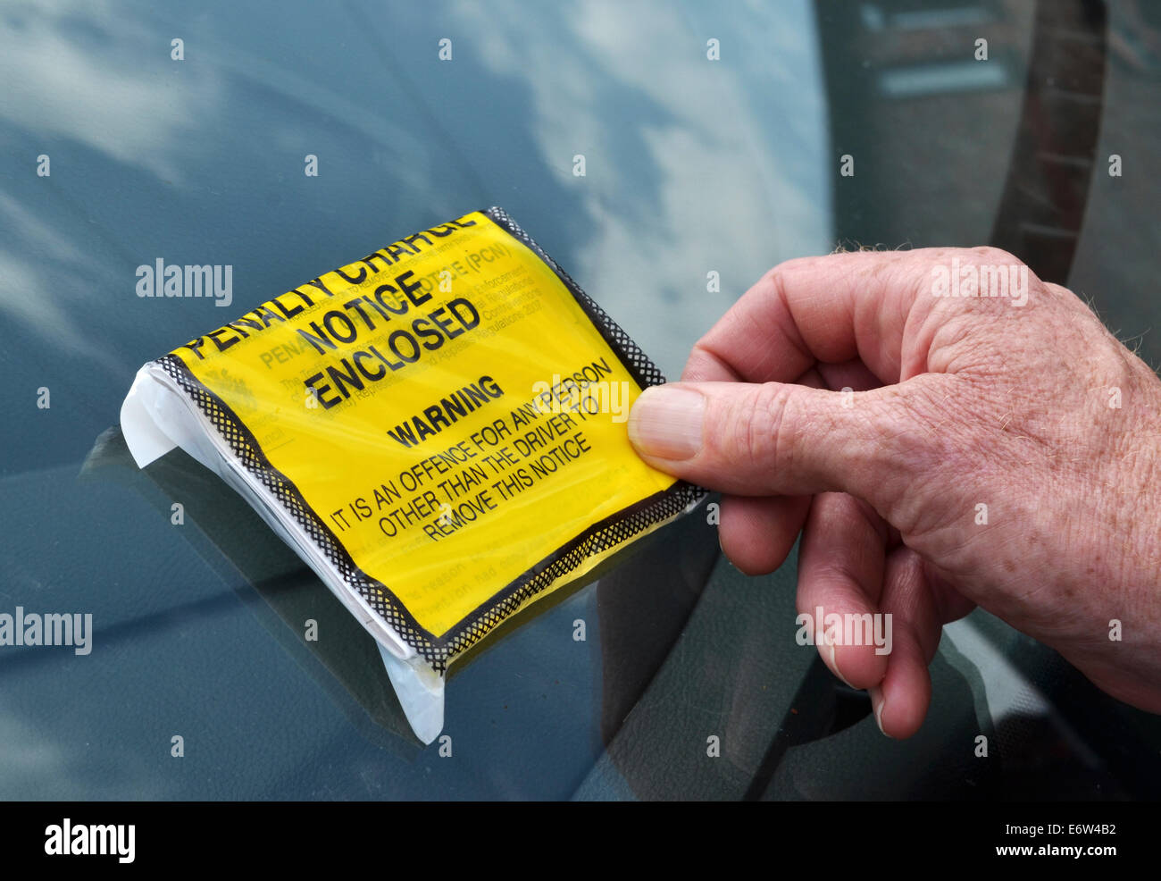 Un automobiliste dépose une pénalité fixe de ticket le pare-brise Banque D'Images