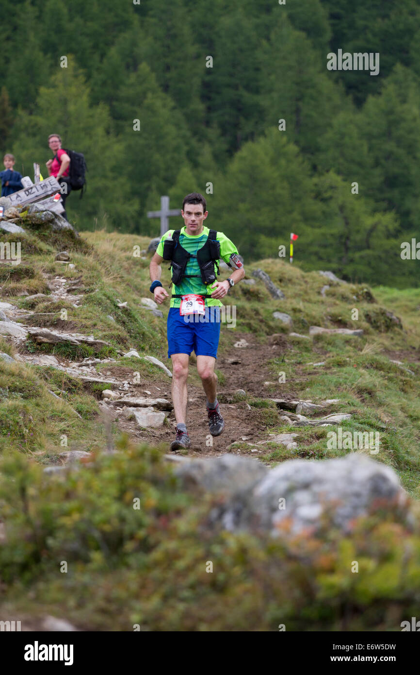 Haut module de finition australien Andrew Tuckey passe au-dessus du col de la Forclaz en Suisse sur le chemin d'une 6e place dans l'UTMB. La course a l'ossature à travers 3 pays alpins (France, Suisse et Italie), plus de nombreux passages de haute montagne pour un total de 163km de course et 9600m de gain de hauteur totale, alors que leur tour du massif du Mont Blanc. La course se déroule en semi-autonomie avec seulement quelques arrêts pour l'alimentation et l'eau. Il est exécuté pour 2 nuits et 2 jours. Le premier porteur atteint Chamonix en moins de 21 heures. Banque D'Images