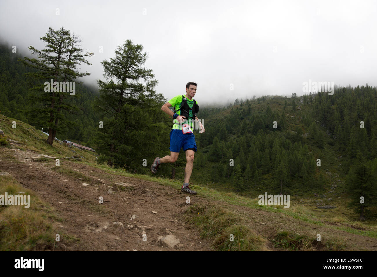 Haut module de finition australien Andrew Tuckey passe au-dessus du col de la Forclaz en Suisse sur le chemin d'une 6e place dans l'UTMB. La course a l'ossature à travers 3 pays alpins (France, Suisse et Italie), plus de nombreux passages de haute montagne pour un total de 163km de course et 9600m de gain de hauteur totale, alors que leur tour du massif du Mont Blanc. La course se déroule en semi-autonomie avec seulement quelques arrêts pour l'alimentation et l'eau. Il est exécuté pour 2 nuits et 2 jours. Le premier porteur atteint Chamonix en moins de 21 heures. Banque D'Images