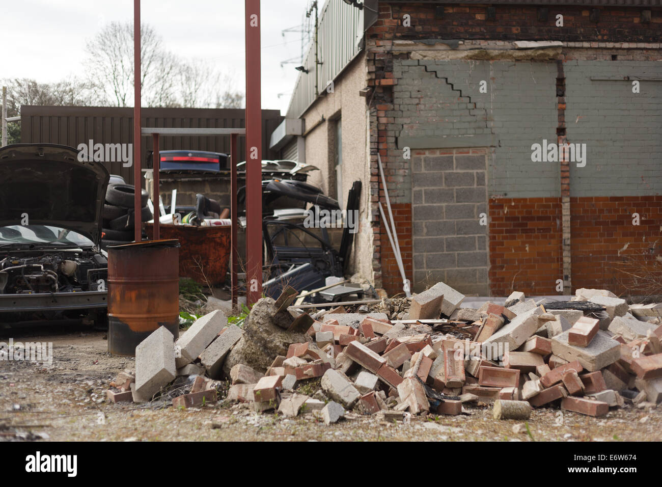 Voiture abandonnée yard briques pièces décombres Banque D'Images