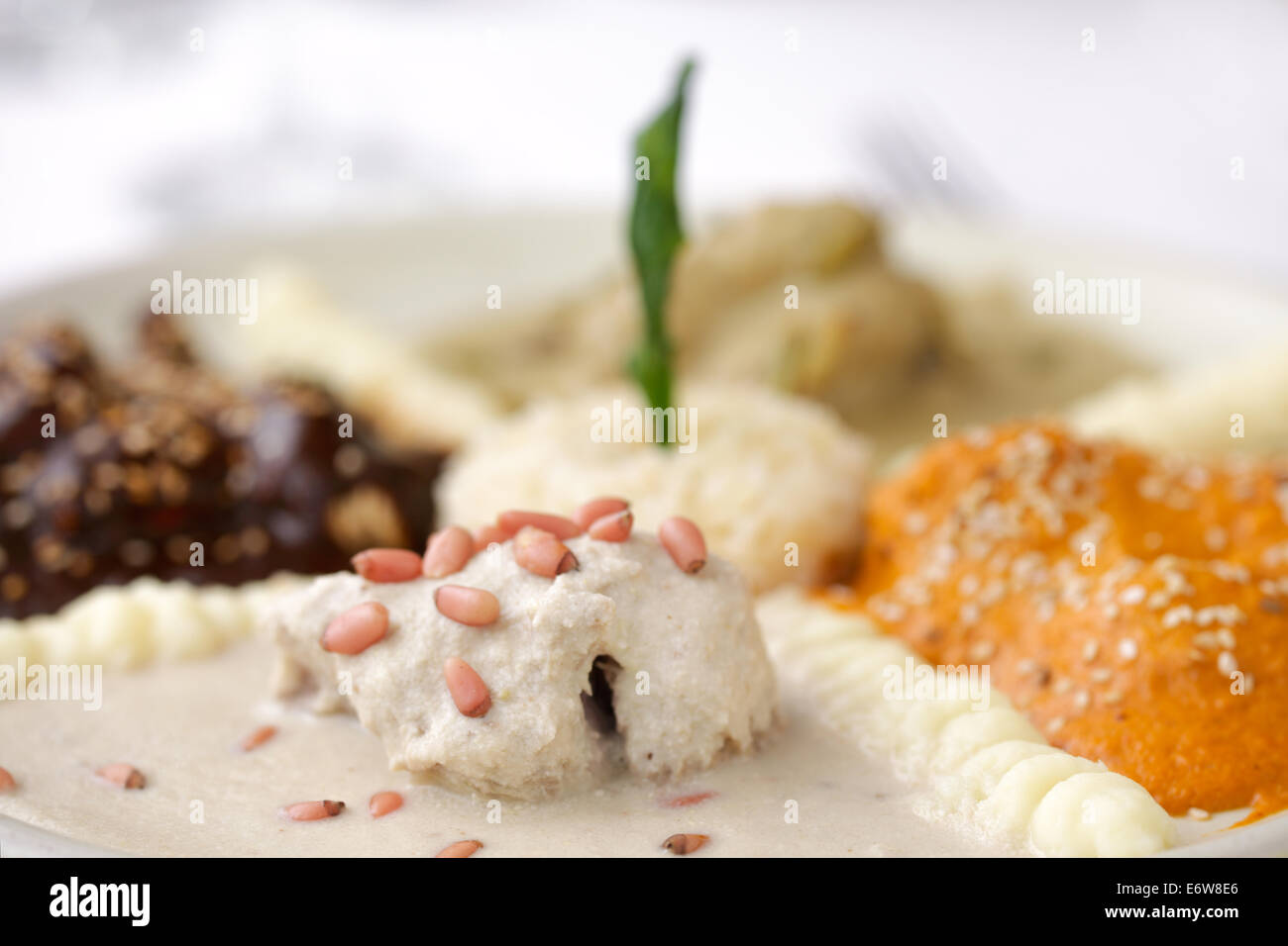 Garnir de pignons de pin sur un plat de poulet de quatre différents 'mole' sauces à Puebla, au Mexique. Banque D'Images