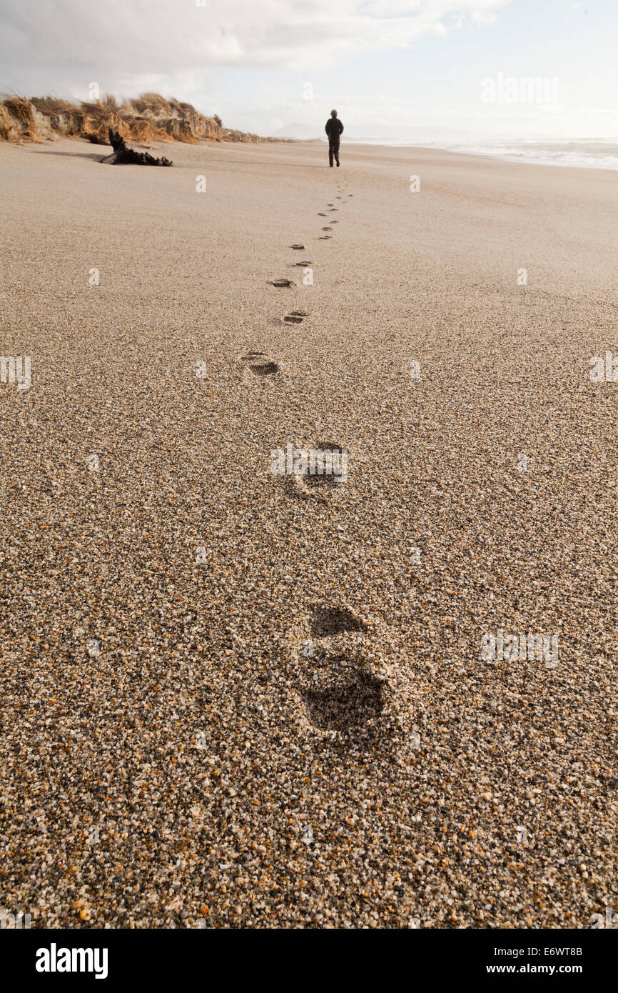 Des empreintes de pas dans le sable grossier, personne qui marche le long de la plage, l'automne, l'île du Sud, Nouvelle-Zélande Banque D'Images