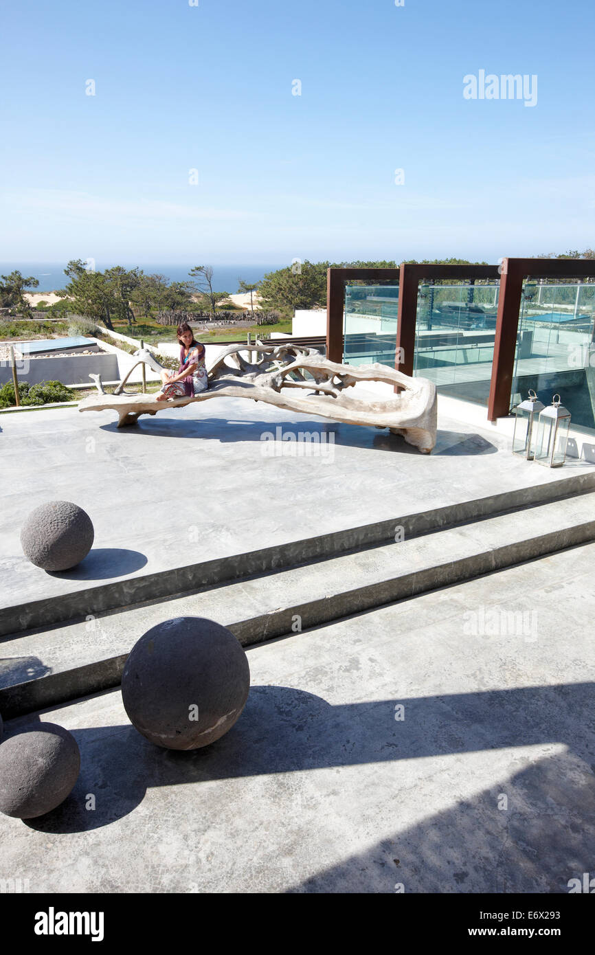 Femme sur le toit-terrasse avec vue sur la mer et la sculpture de bois flotté, Hôtel Areias do Seixo, Povoa de Penafirme, A-dos-Cunhados, coût Banque D'Images