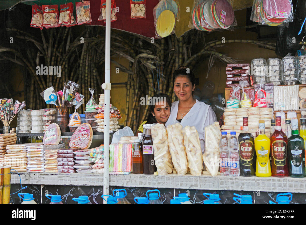 La mère, 25 ans, et sa fille, 7 ans, de vendre des bonbons et des boissons faites à partir de la canne à sucre, Puyo, province de Pastaza, Equateur Banque D'Images