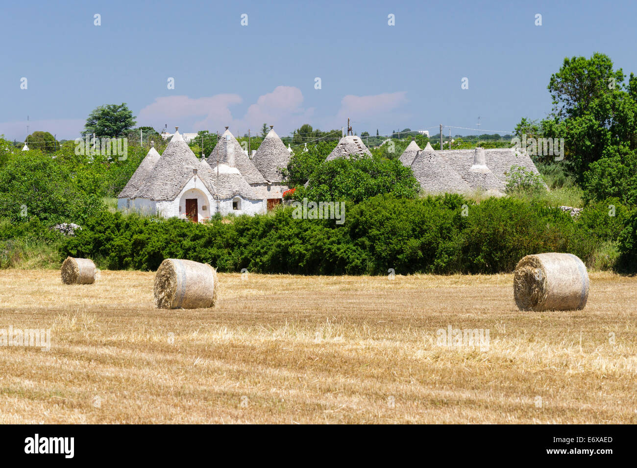 Champ de chaumes, bottes de paille, maisons Trulli, maisons rondes traditionnelles, à l'arrière, près de Locorotondo, Valle d'Itria, Pouilles, Italie Banque D'Images