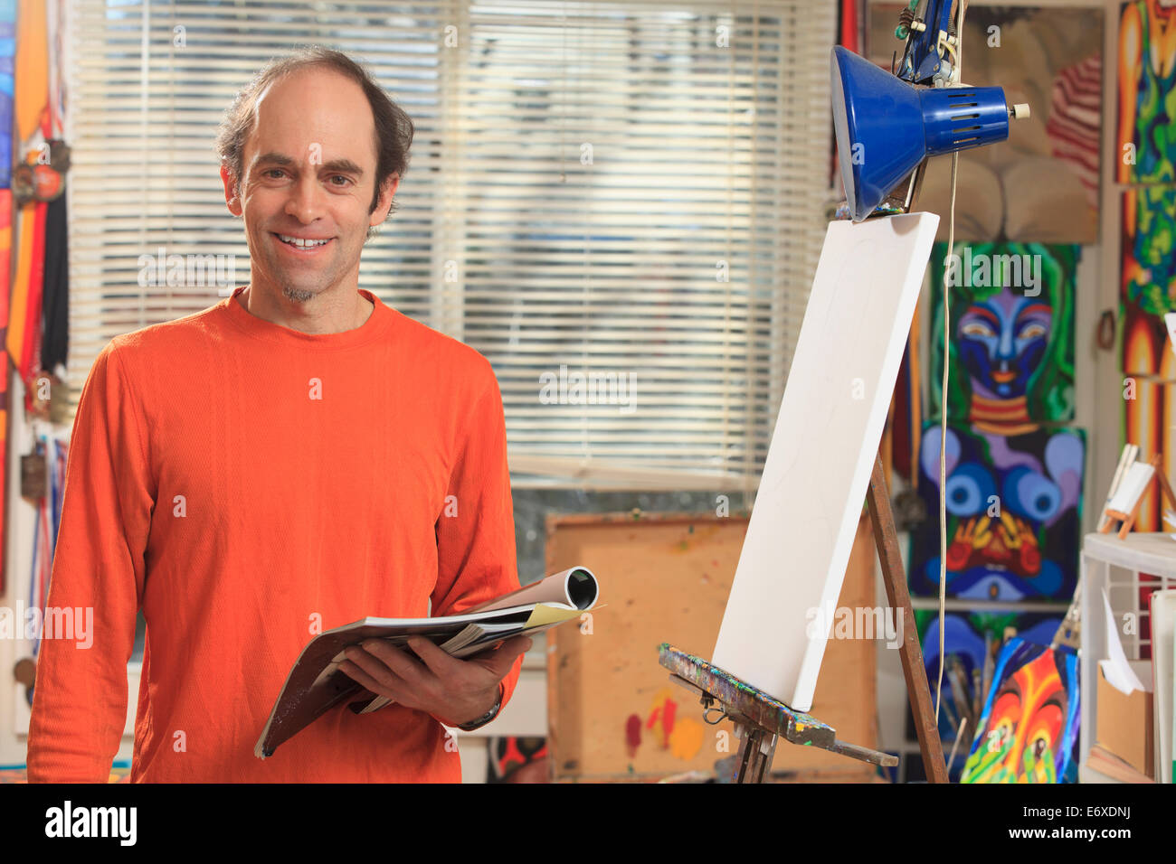 Homme avec Aspergers tenant son matériel de référence pour sa peinture dans un studio d'art Banque D'Images
