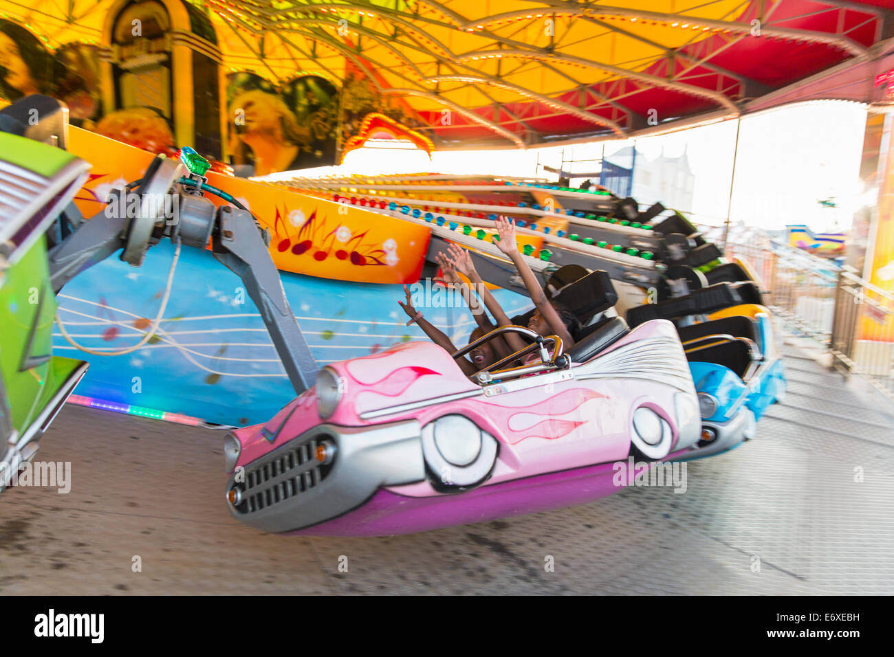 USA,New Jersey Atlantic City,acier,Pier,midway amusement park ride with kids holding arms up Banque D'Images