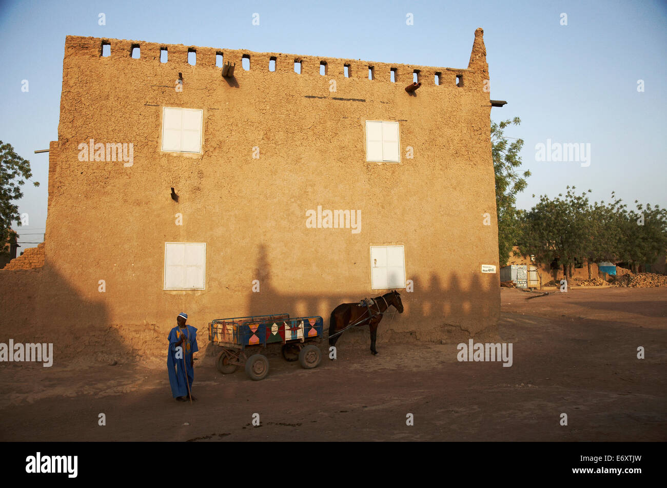 L'homme et un cheval panier à l'avant d'un bâtiment de boue, Djenné, région de Mopti, au Mali Banque D'Images