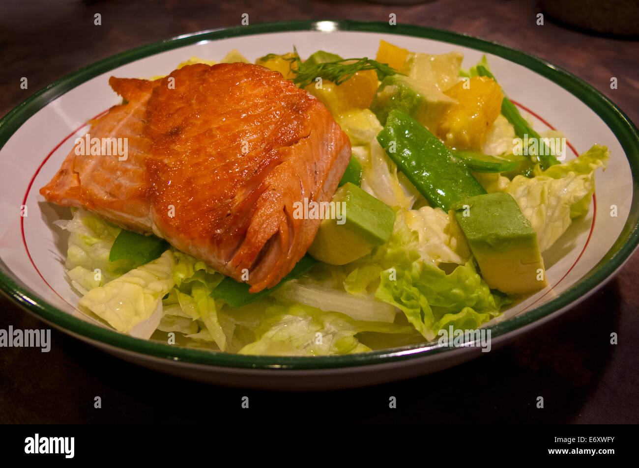 Délicieux filets de saumon sauvage du Pacifique poêlés sur une salade de laitue pois mange-tout, les oranges, et d'avocat dans une vinaigrette aux agrumes. Banque D'Images