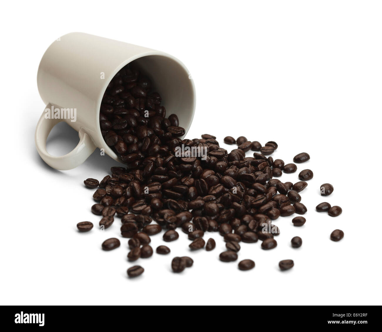 Tasse à café avec haricots renversé isolé sur fond blanc. Banque D'Images