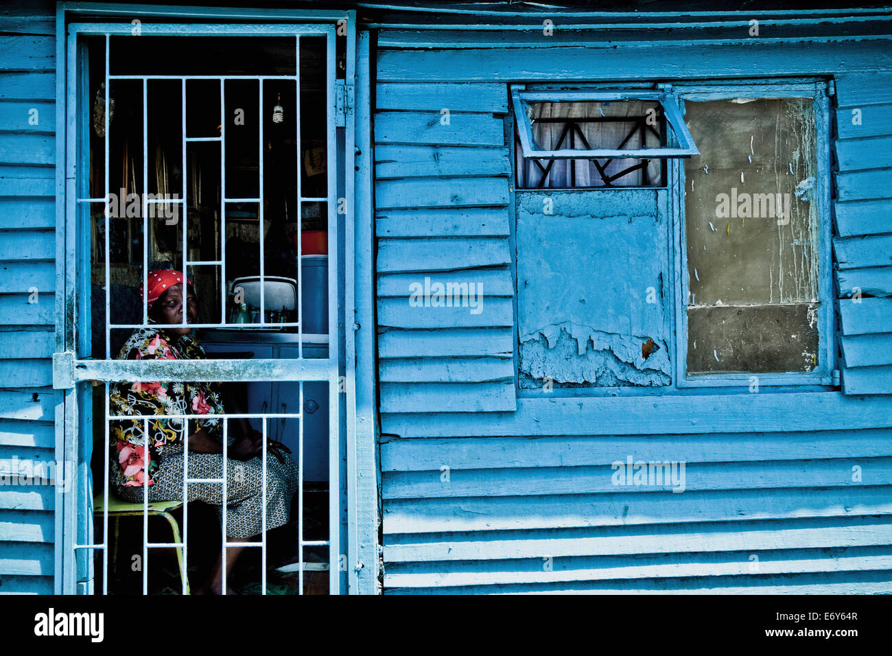 Femme assise dans sa hutte derrière une porte, Langa township, Cape Town, Afrique du Sud, l'Afrique Banque D'Images