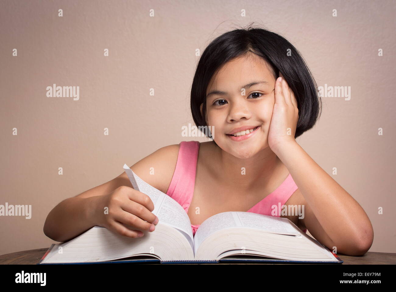 Jeune fille portant des lunettes la lecture à la maison Banque D'Images