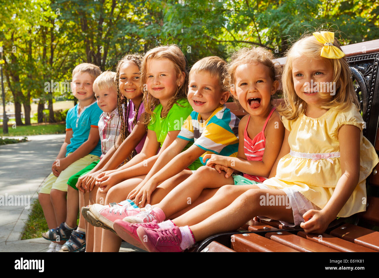 Les enfants sur banc de parc d'été Banque D'Images