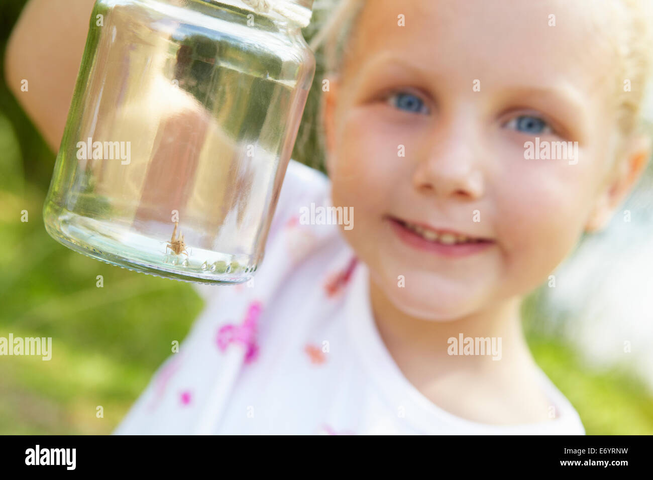 Petite fille avec le cricket dans un pot Banque D'Images