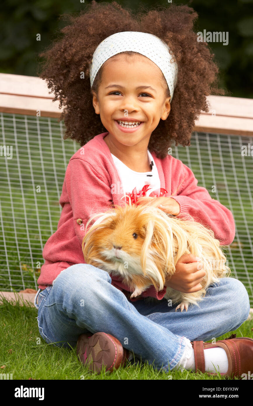 Young Girl in garden holding cochon Banque D'Images