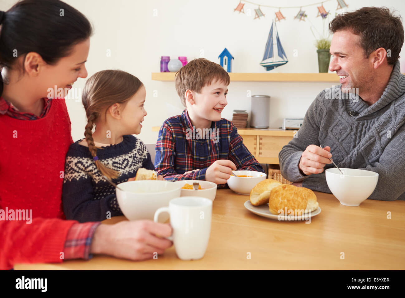 Famille ayant un bol de soupe pour le déjeuner Banque D'Images