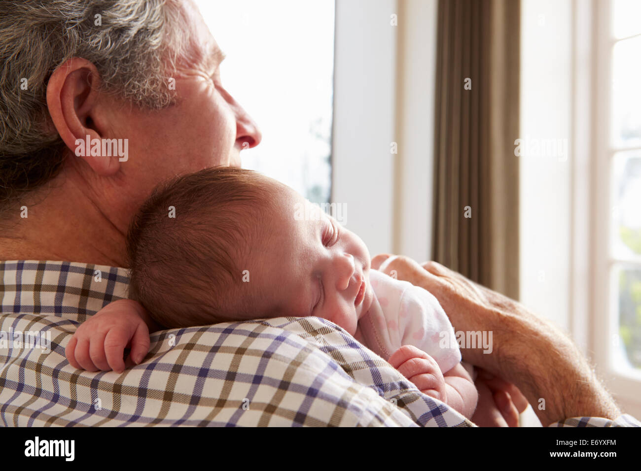 Jeune homme avec chien assis On Sofa Using Digital Tablet Banque D'Images