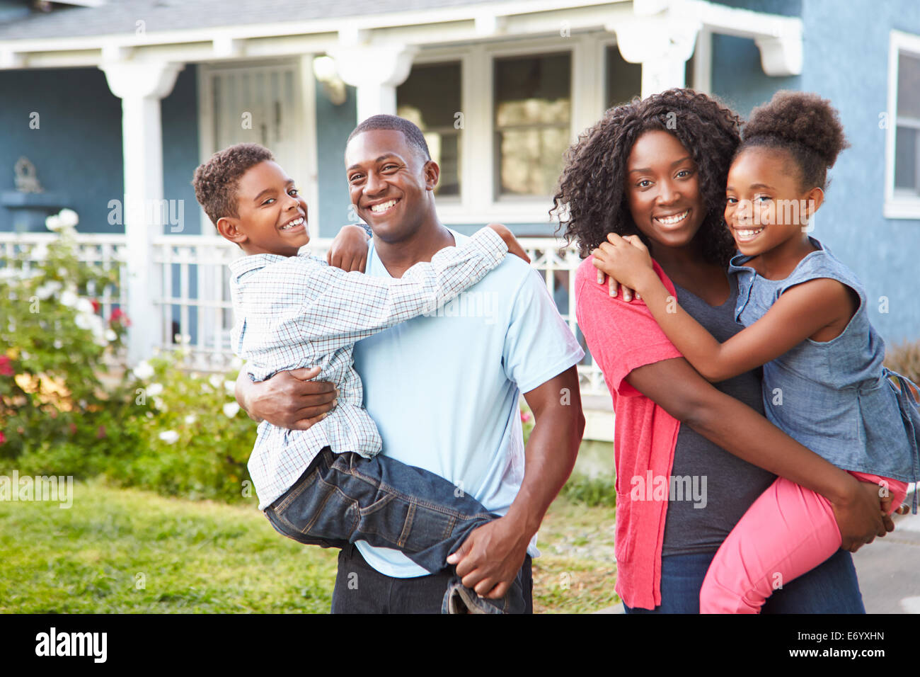 Portrait de famille à l'extérieur de la maison de banlieue Banque D'Images