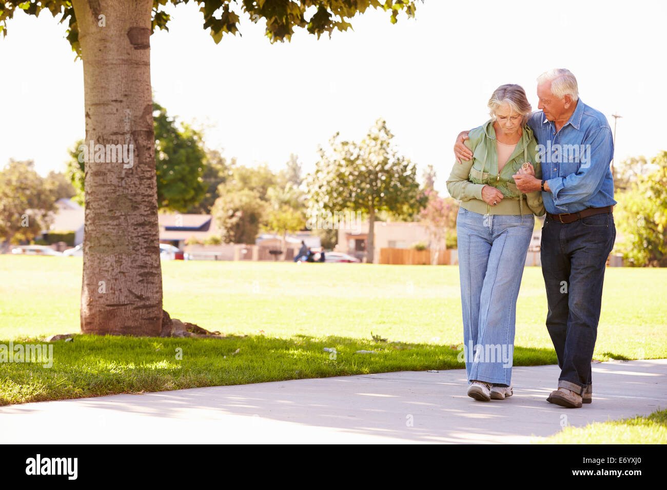 Senior Femme aider comme ils marchent dans Parc Banque D'Images Senior Femme aider comme ils marchent dans Parc Banque D'Images