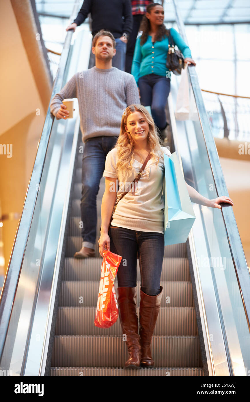 Femme Shopper sur Escalator dans Shopping Mall Banque D'Images