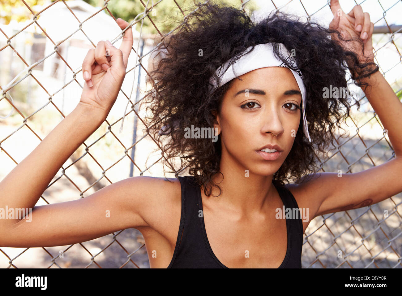 Portrait de jeune femme en milieu urbain pour Standing By Fence Banque D'Images