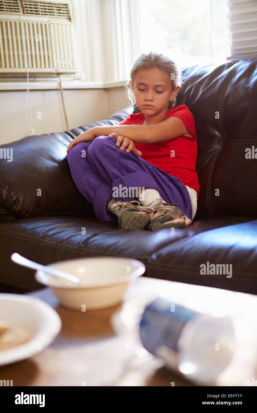 Malheureux Girl Sitting on Sofa At Home Banque D'Images