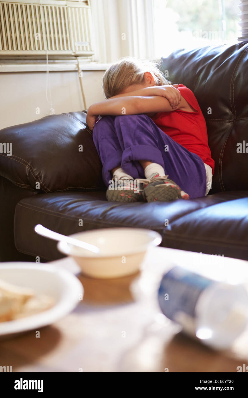 Malheureux Girl Sitting on Sofa At Home Banque D'Images