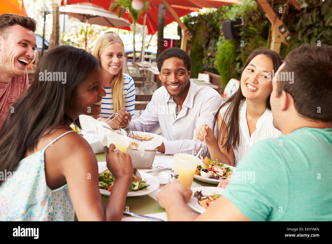 Groupe d'amis appréciant le déjeuner en restaurant en plein air Banque D'Images