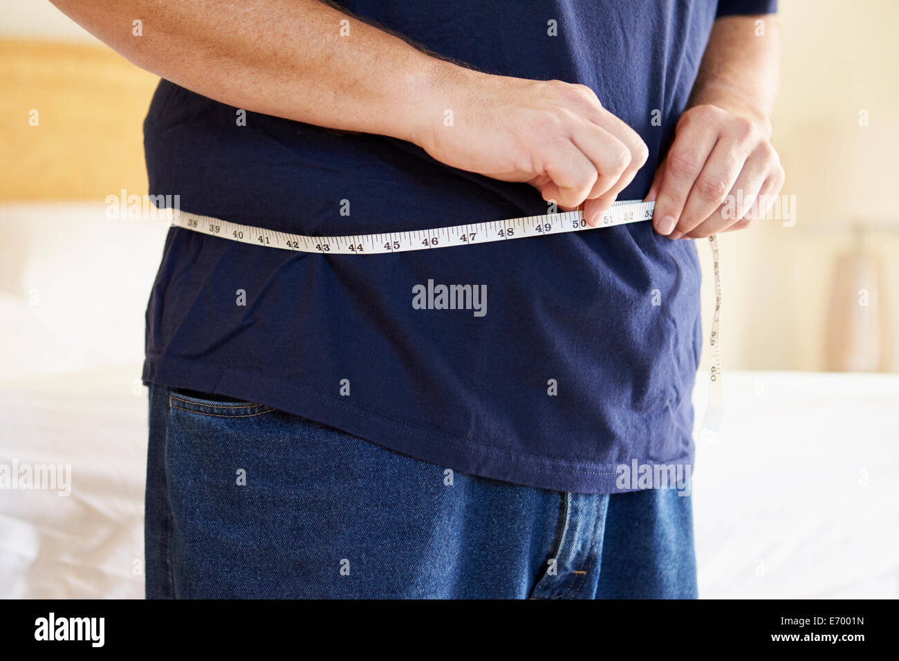 Close Up of Overweight Man Measuring Waist Banque D'Images