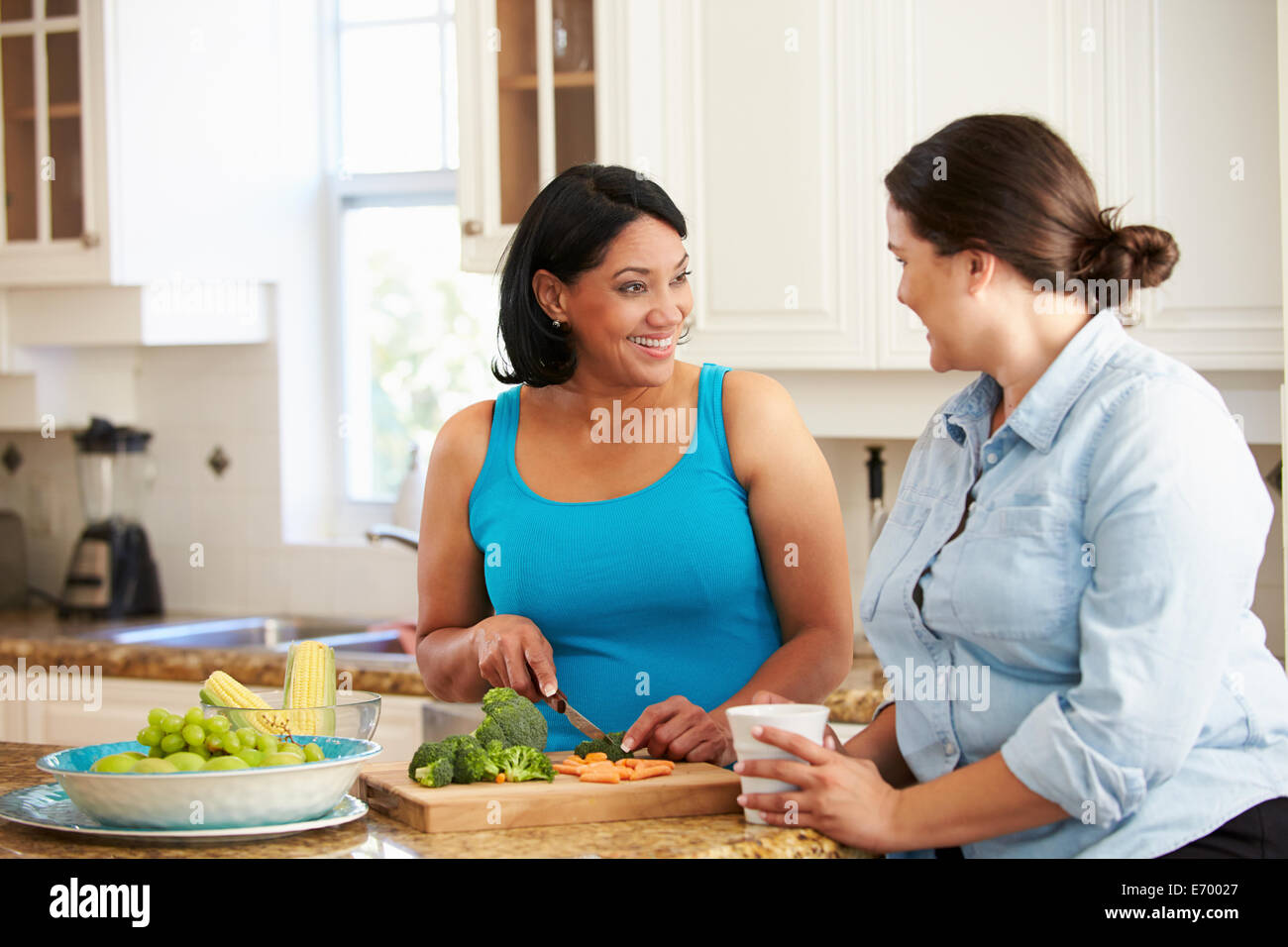 Deux femmes en surpoids sur l'alimentation La préparation de légumes dans la cuisine Banque D'Images