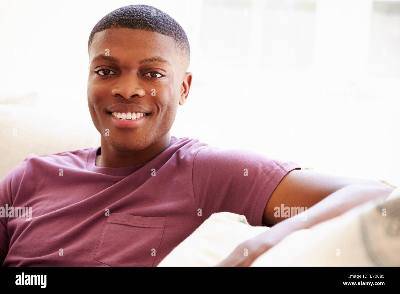 Portrait of Young Man Sitting on Sofa Banque D'Images