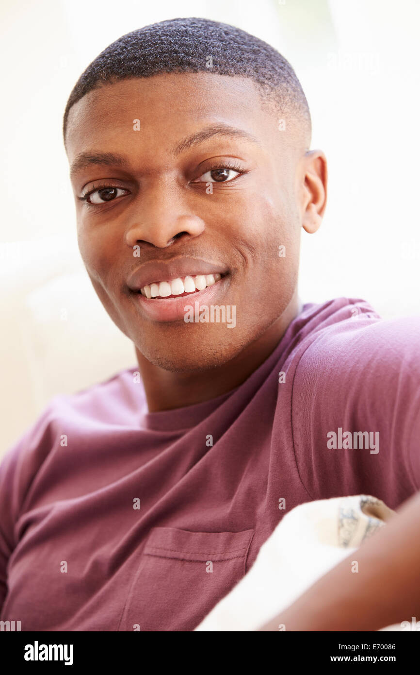 Portrait of Young Man Sitting on Sofa Banque D'Images