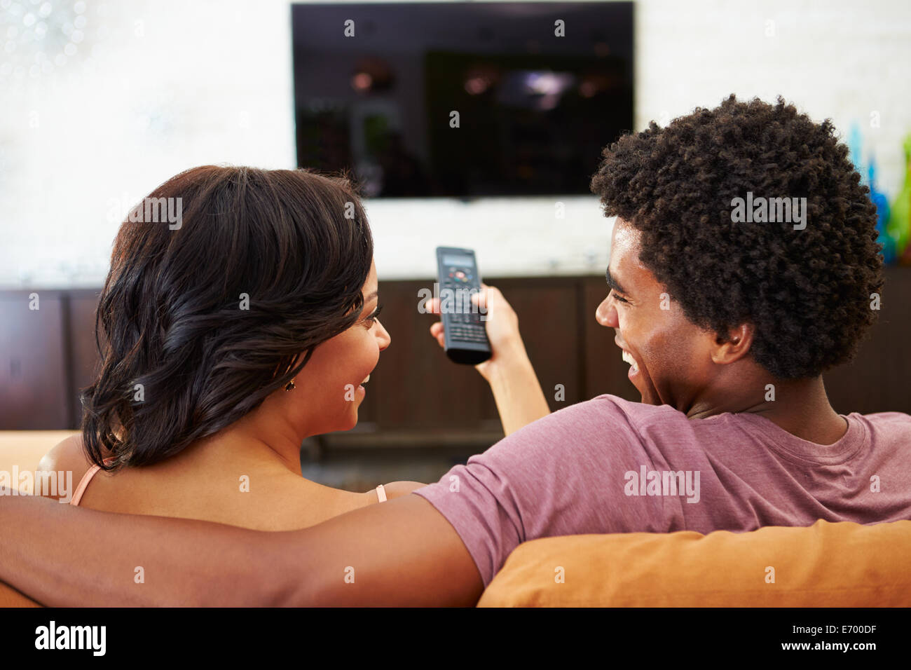 Vue arrière du couple Sitting on Sofa à regarder la télévision ensemble Banque D'Images